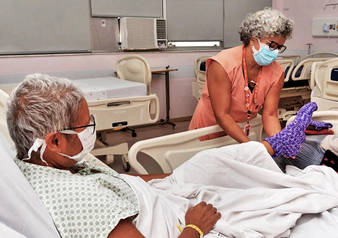 Paciente idoso com Cancêr sendo cuidado por uma voluntária - IncaVoluntario - INCA